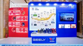 A display booth featuring Valvoline GEELY collaboration, showcasing co-developed lubricants and a timeline of their partnership, with product bottles arranged on a central table.